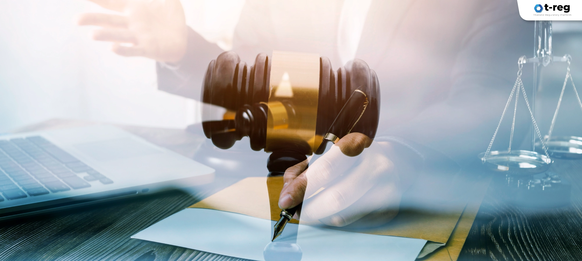 ภาพแนวคิดกฎหมาย แสดงค้อนตุลาการและตาชั่งความยุติธรรม บนโต๊ะทำงานพร้อมมือกำลังเซ็นเอกสาร