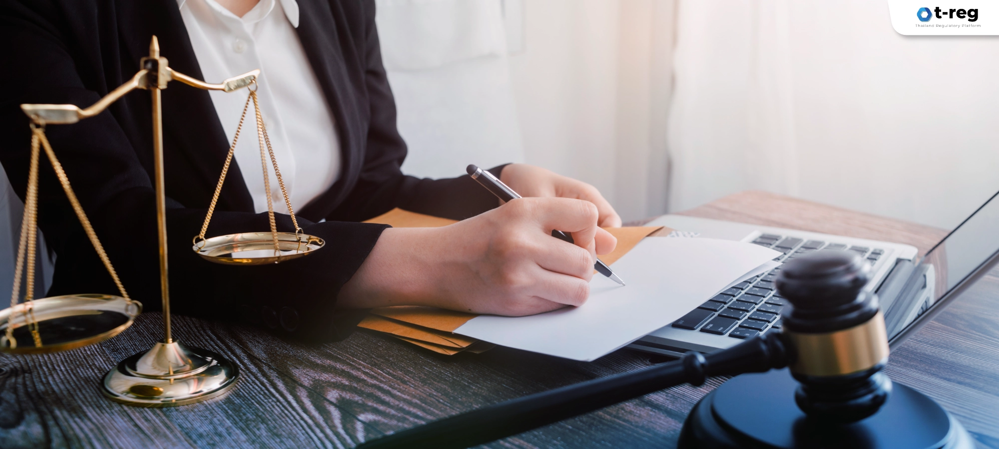 ภาพบุคคลเขียนเอกสารข้างคอมพิวเตอร์ มีตาชั่งและค้อนผู้พิพากษา สื่อถึงกฎหมายและการกำกับดูแลข้อมูล PDPA